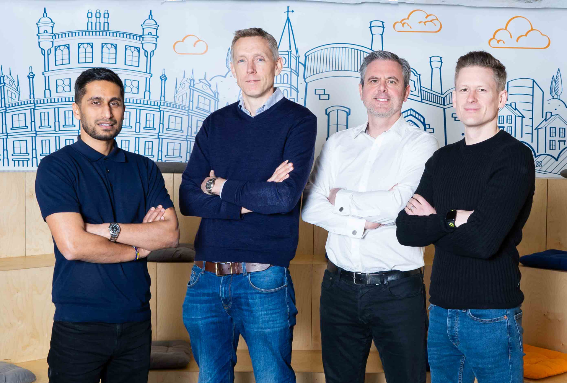 Four company directors photographed together against an illustrated office mural in Bristol